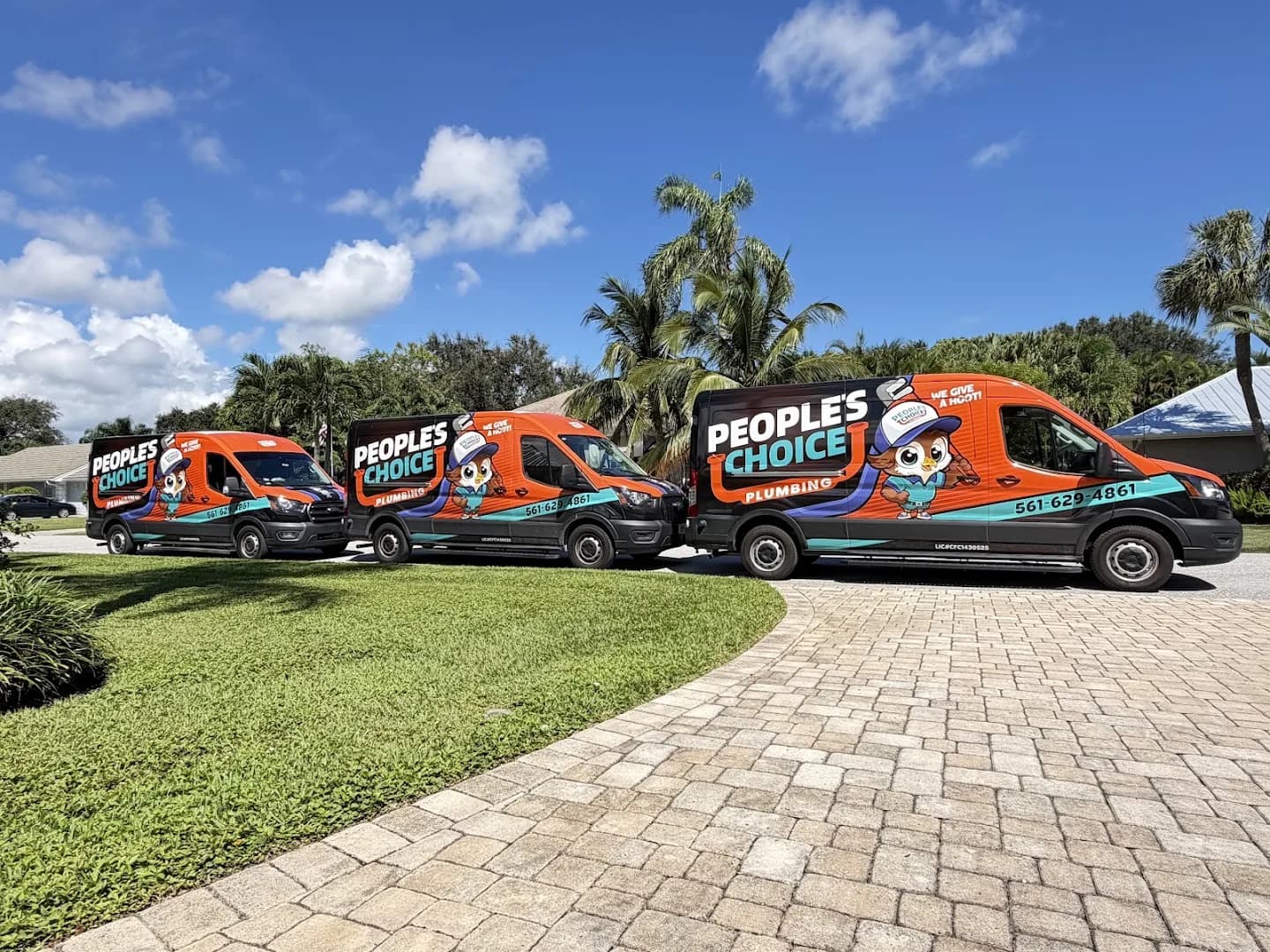 Three branded People's Choice Plumbing vans on a Florida driveway