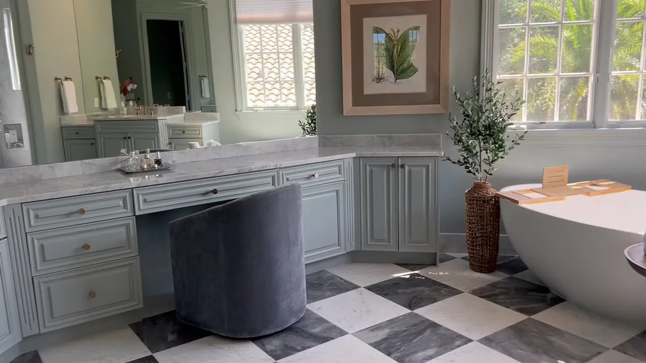 Luxury bathroom with freestanding tub, marble checkerboard floor, and double vanity